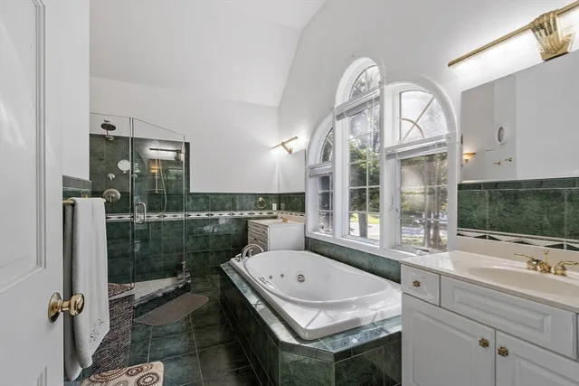 a bathroom with a tub a sink and a large window