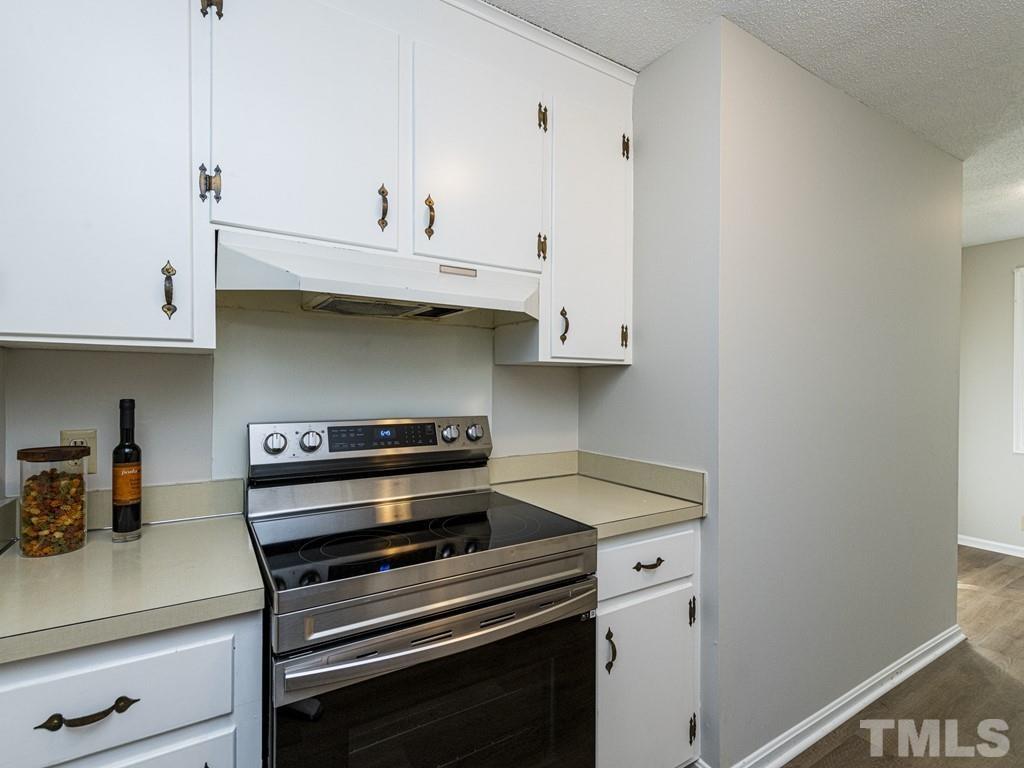 2933 Wycliff Road Raleigh, NC 27607 - Photo 8 of 30 a kitchen with a stove and white cabinets