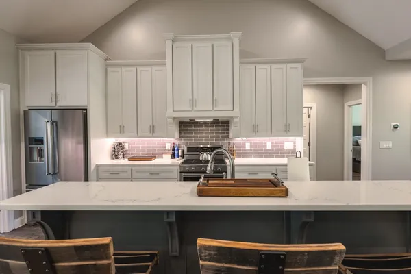 a large kitchen with kitchen island a stove a sink a dining table and chairs