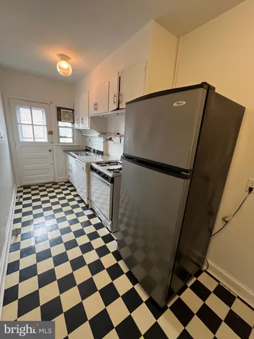 a kitchen with a black white checkered floor and a refrigerator