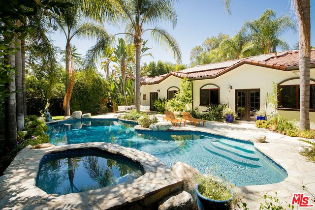 a view of a white house with a swimming pool and a yard