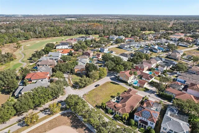 an aerial view of residential houses with outdoor space and parking