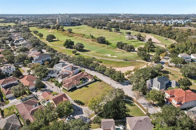 an aerial view of residential houses with outdoor space and trees