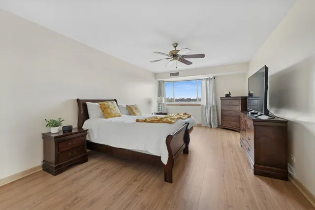 a spacious bedroom with a bed and a flat screen tv