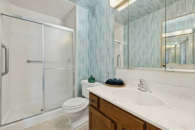 a bathroom with a sink a toilet and shower