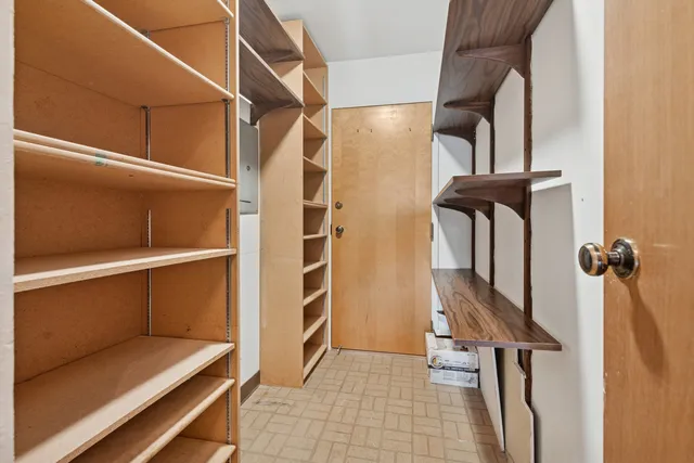 a view of walk in closet with clothes and shoes