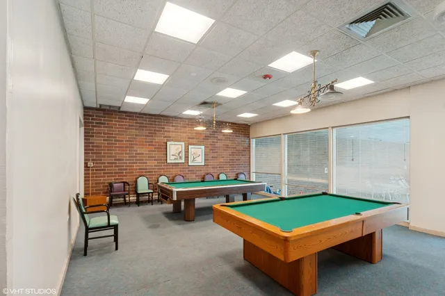 a room with pool table and windows