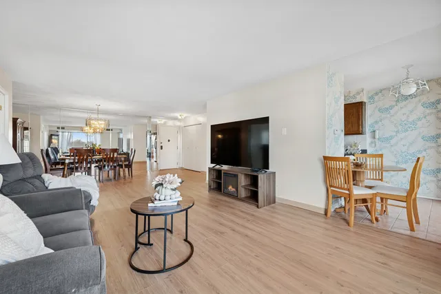 a living room with furniture a flat screen tv and a dining table with wooden floor