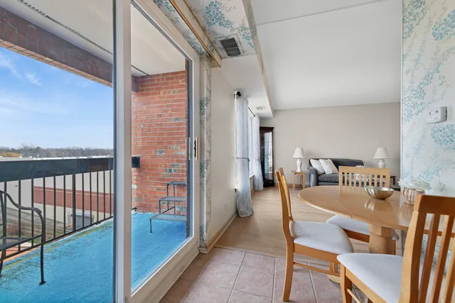 a dining room with furniture and a floor to ceiling window