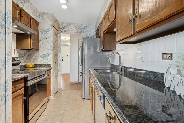 a kitchen with stainless steel appliances granite countertop a sink and a stove