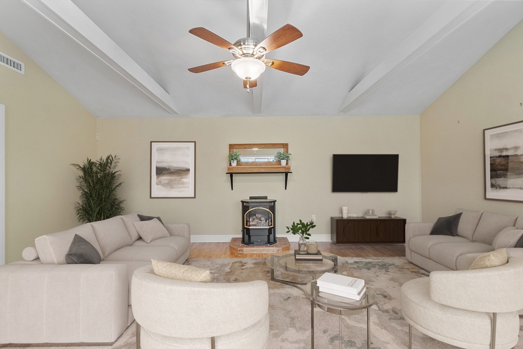 73 Forest Road Millis, MA 02054 - Photo 13 of 34 a living room with furniture a fireplace and a flat screen tv