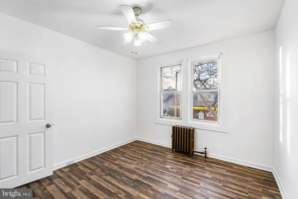 an empty room with windows and ceiling fan