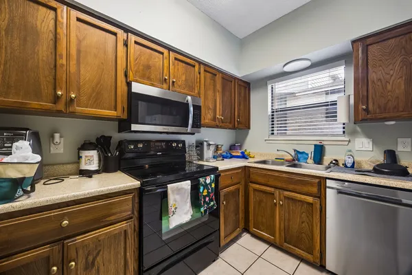 a kitchen with stainless steel appliances a stove sink microwave and cabinets
