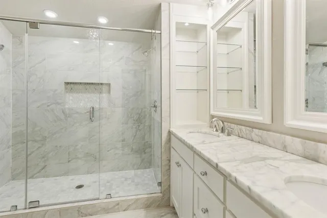 a bathroom with a granite countertop sink a shower and a mirror