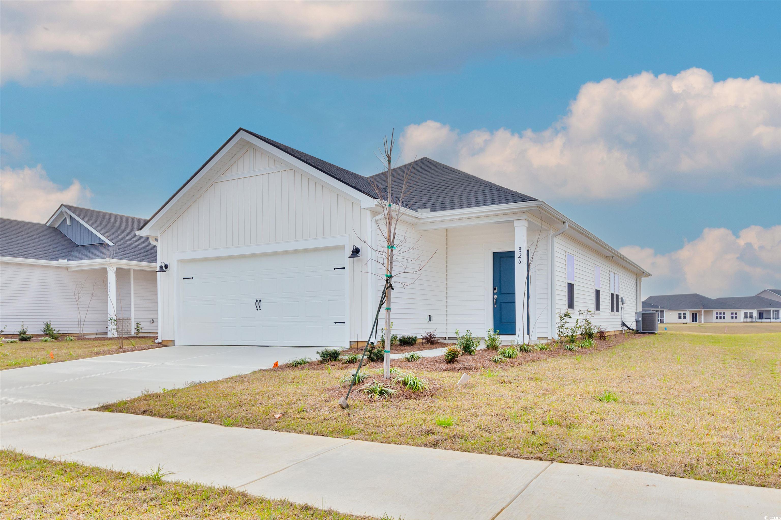 826 Cypress Preserve Circle Longs, SC 29568 - Photo 2 of 27 View of front of property with cooling unit, board and batten siding, driveway, a front lawn, and a garage