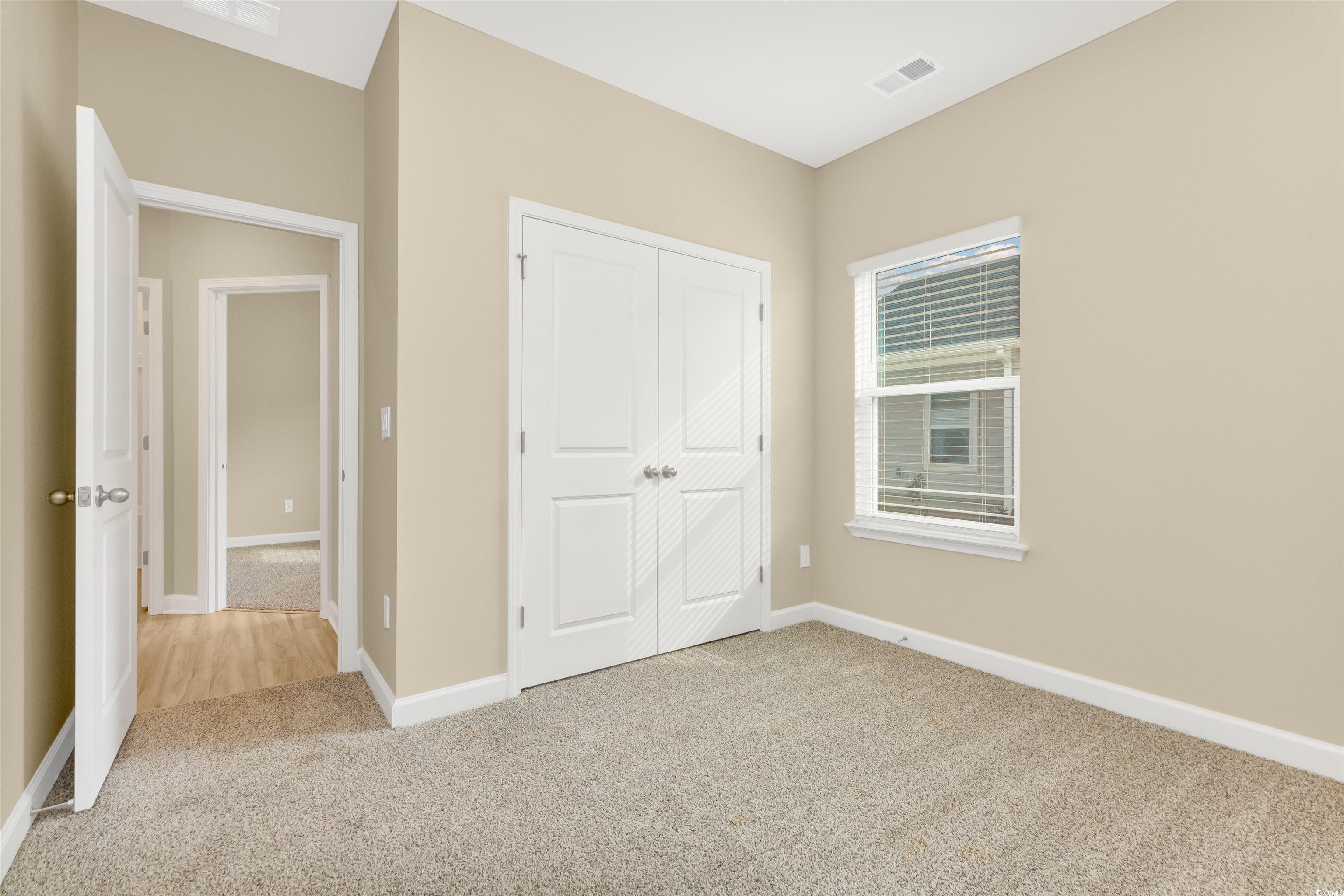 826 Cypress Preserve Circle Longs, SC 29568 - Photo 22 of 27 Unfurnished bedroom featuring baseboards, carpet, a closet, and visible vents