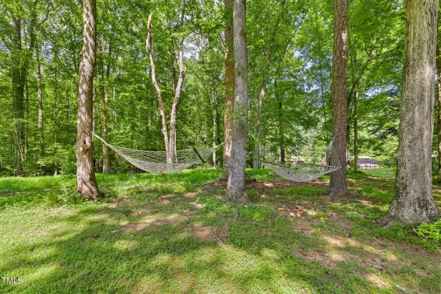 an aerial view of residential house with outdoor space and trees all around