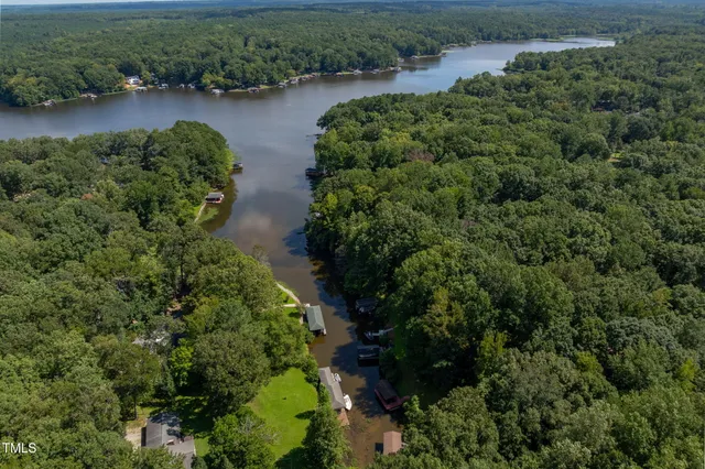 an aerial view of residential house with outdoor space and trees all around