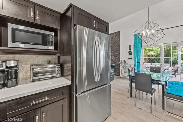 a kitchen with stainless steel appliances a refrigerator a stove a microwave and dining table