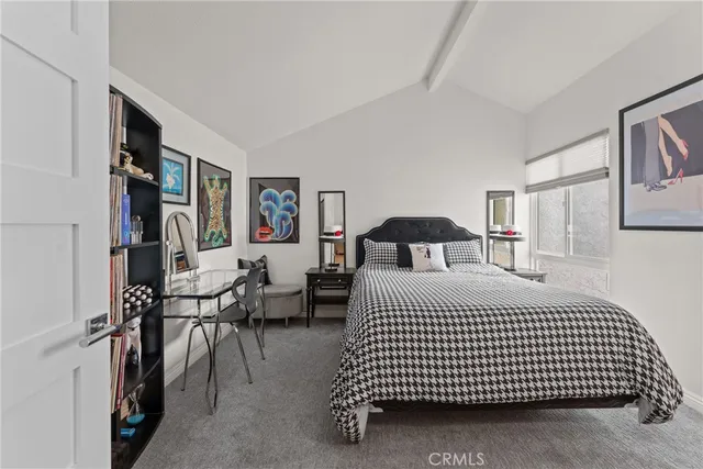 a bedroom with a bed mirror and painting on the wall