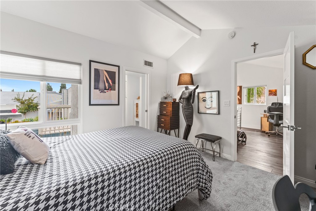 12720 Newport Avenue, Unit 18 Tustin, CA 92780 - Photo 23 of 37 a bedroom with a bed mirror and painting on the wall