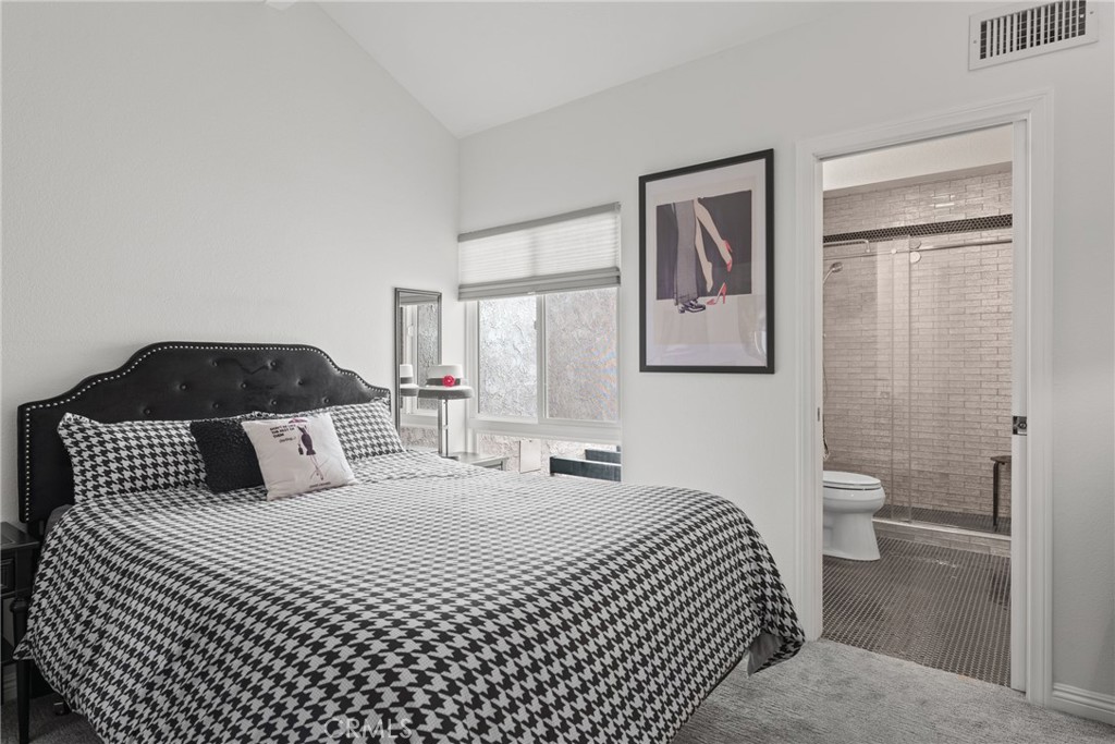 12720 Newport Avenue, Unit 18 Tustin, CA 92780 - Photo 24 of 37 a bedroom with a large bed and a lamp on dresser