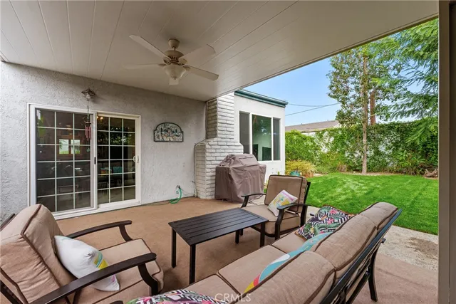 a view of a patio with table and chairs potted plants and large tree