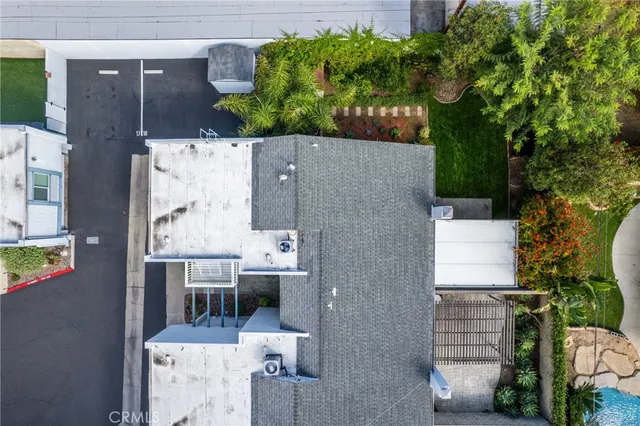 an aerial view of a house with a swimming pool a yard and mountain view