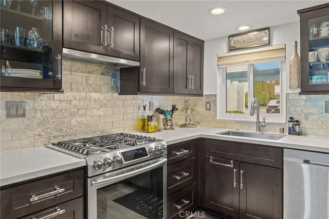 a kitchen with stainless steel appliances granite countertop a sink stove and cabinets