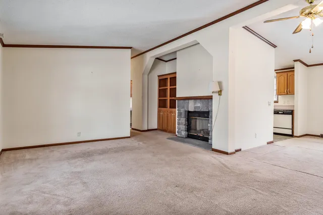 an empty room with windows and refrigerator