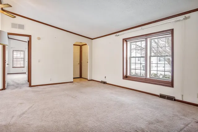 a view of a big room with windows and chandelier