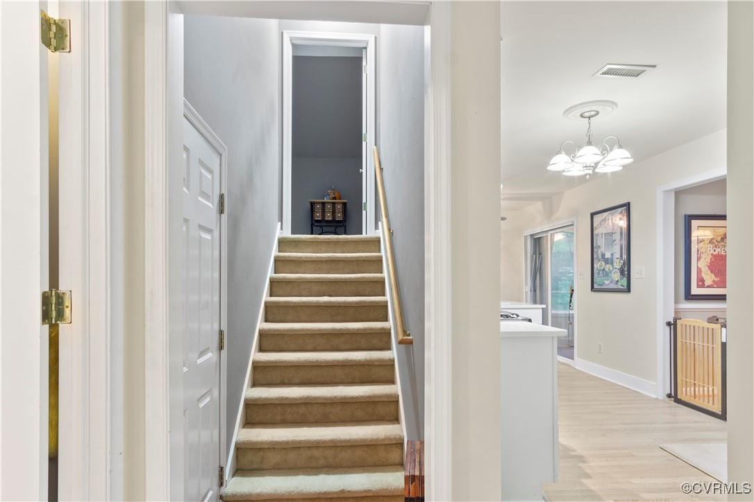 4824 Bristol Circle Williamsburg, VA 23185 - Photo 27 of 36 Staircase with an inviting chandelier and hardwood