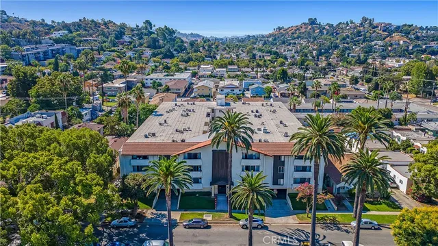 aerial view of multi story residential apartment building with yard