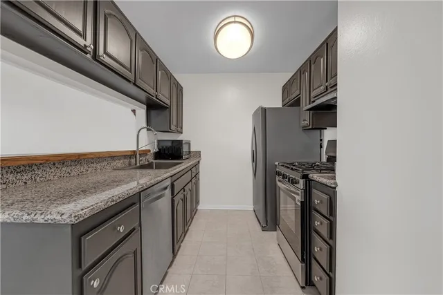 a kitchen with stainless steel appliances granite countertop a stove and a microwave