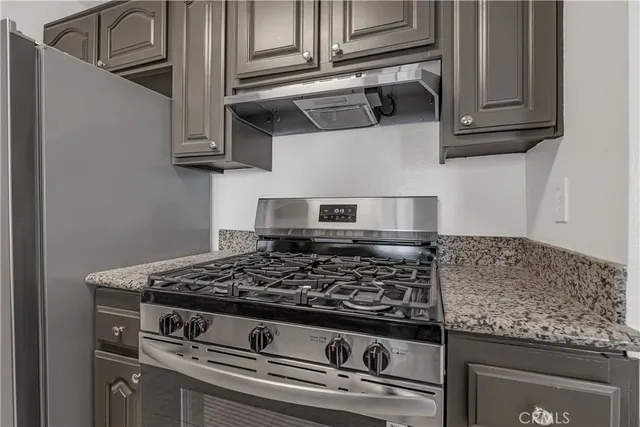 a kitchen with granite countertop a sink and cabinets