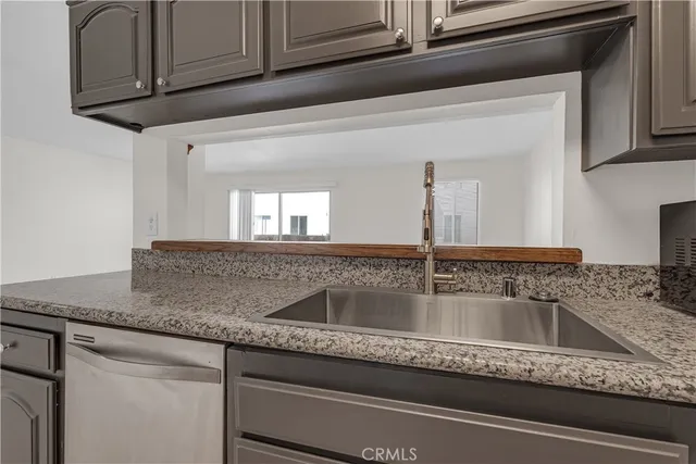 a kitchen with stainless steel appliances granite countertop a sink and a stove