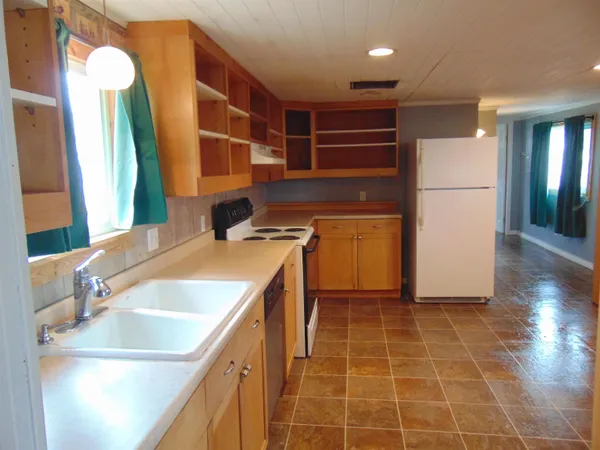 a view of a kitchen with a sink and a refrigerator