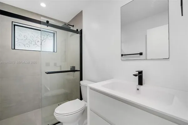 a bathroom with a sink a toilet a shower and a mirror