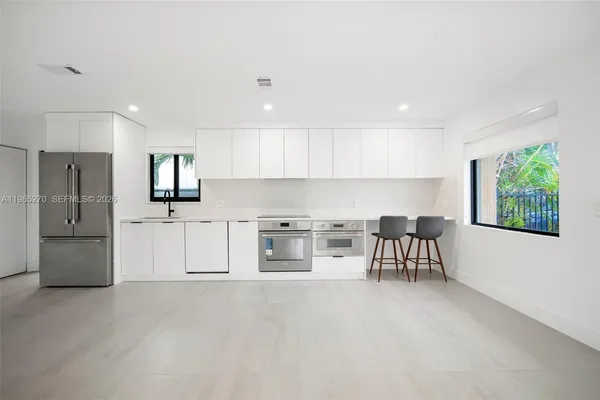 a kitchen with stainless steel appliances a refrigerator and a stove top oven