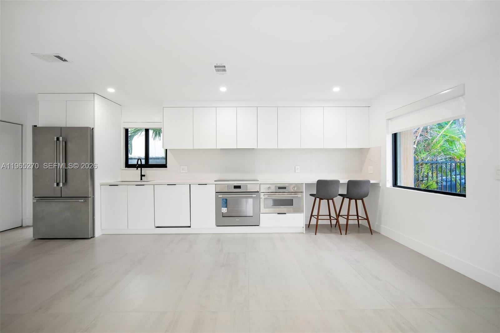 3668 Southwest 26th Street Miami, FL 33133 - Photo 4 of 16 a kitchen with stainless steel appliances a refrigerator and a stove top oven