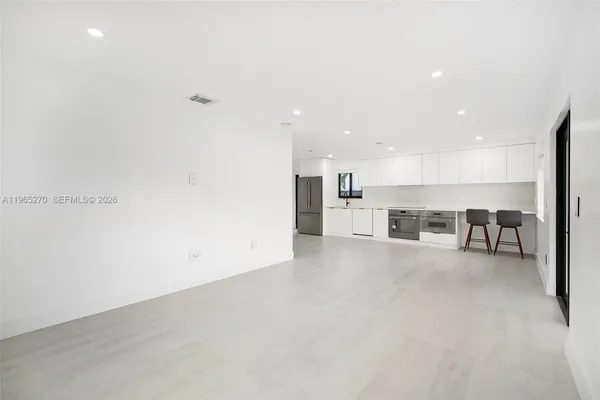 a view of a kitchen with a sink and chairs