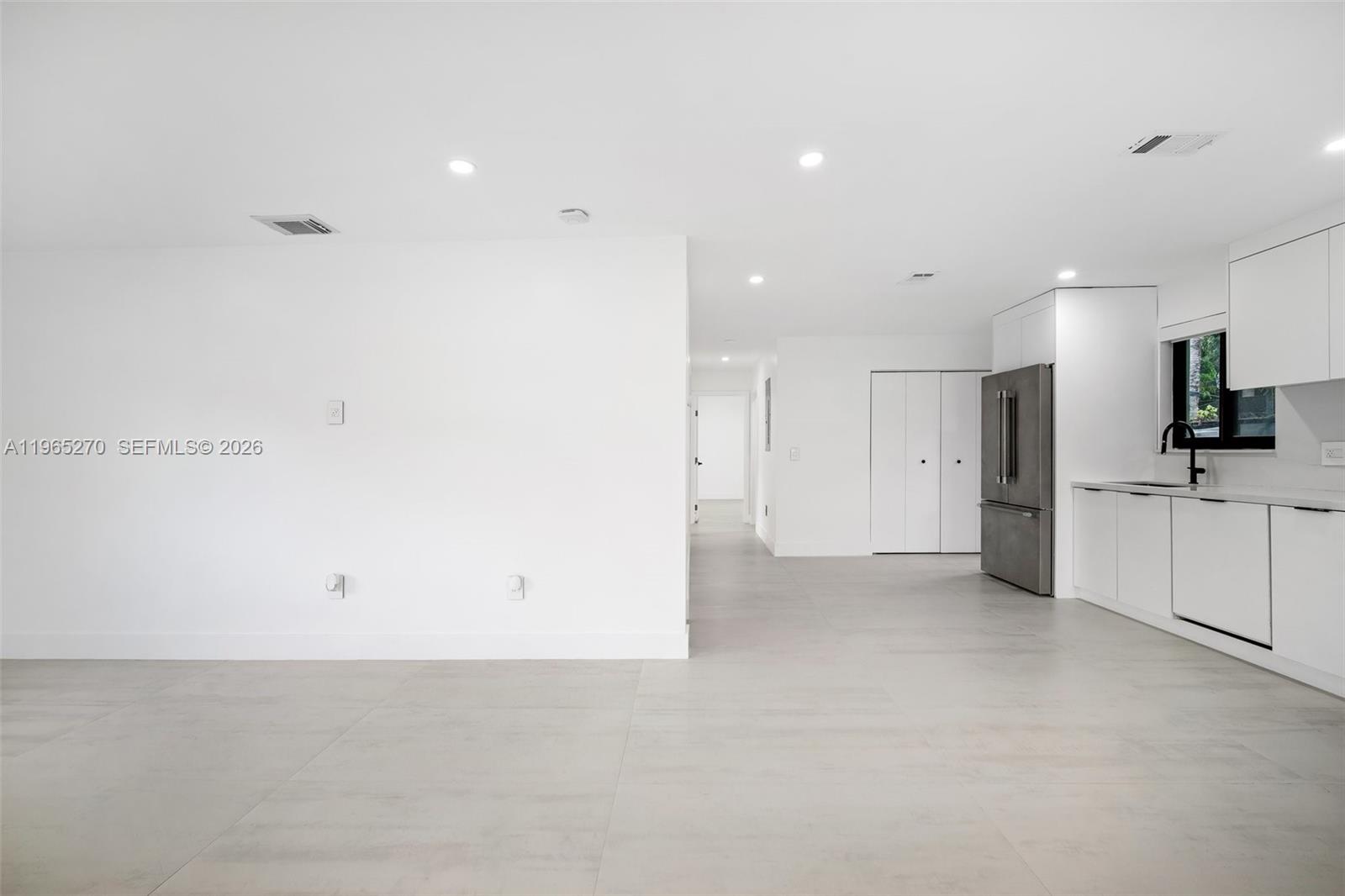 3668 Southwest 26th Street Miami, FL 33133 - Photo 9 of 16 a view of a kitchen with a refrigerator and white cabinets