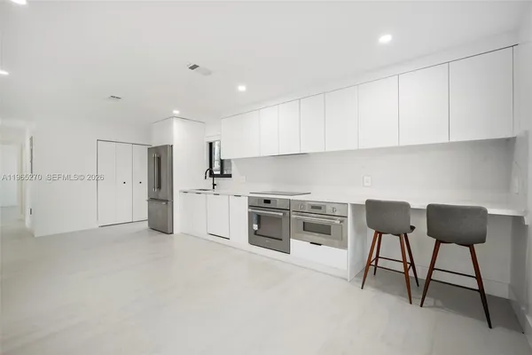 a kitchen with stainless steel appliances granite countertop a stove a sink and a refrigerator