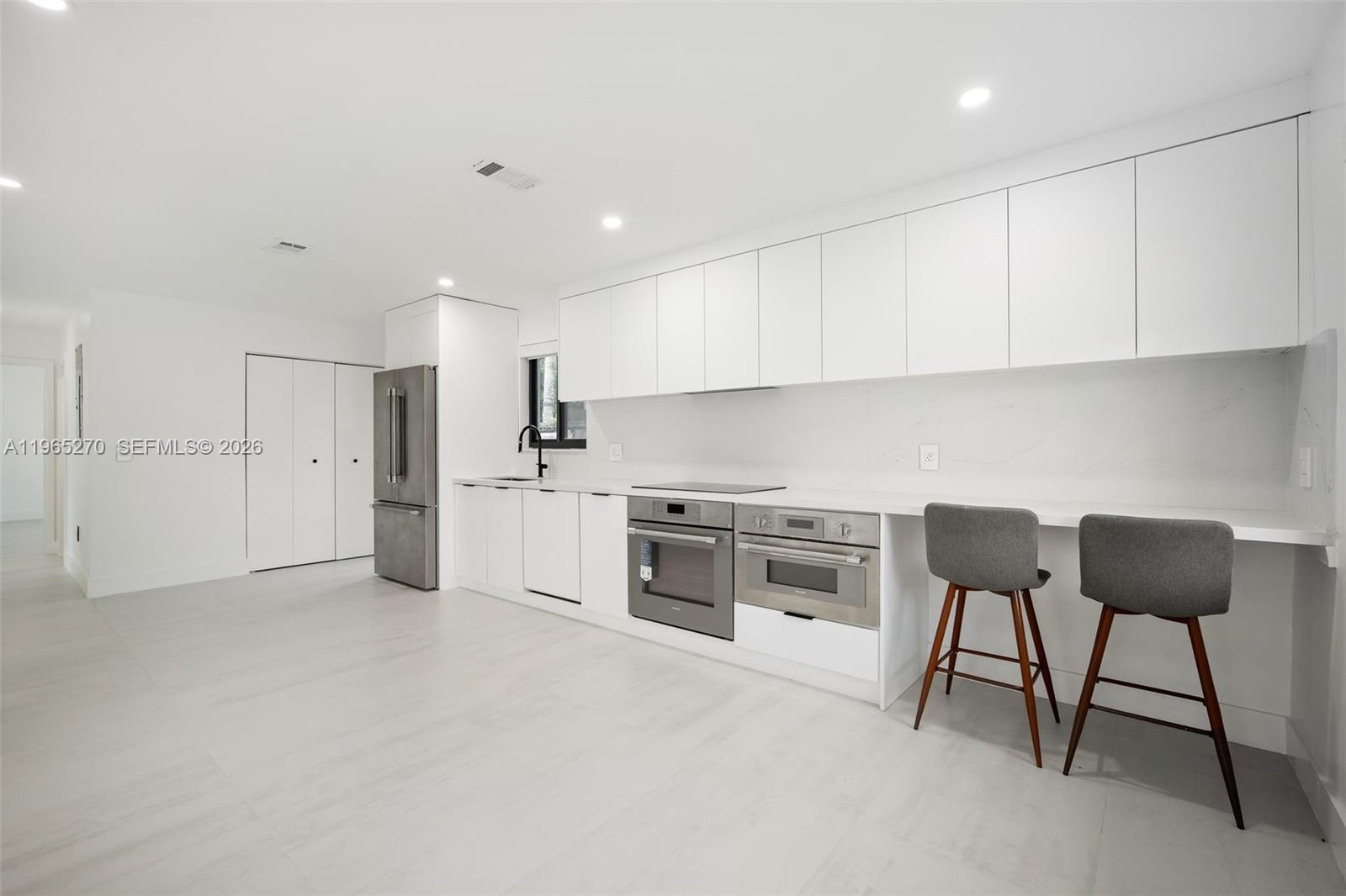 3668 Southwest 26th Street Miami, FL 33133 - Photo 10 of 16 a kitchen with stainless steel appliances granite countertop a stove a sink and a refrigerator