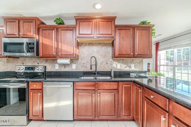 a kitchen with stainless steel appliances granite countertop a refrigerator and a stove top oven