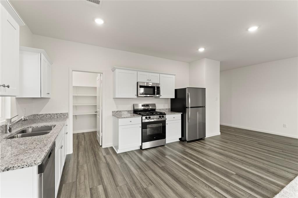 1324 Kennedy Road Howe, TX 75459 - Photo 13 of 29 a kitchen with granite countertop stainless steel appliances and wooden cabinets