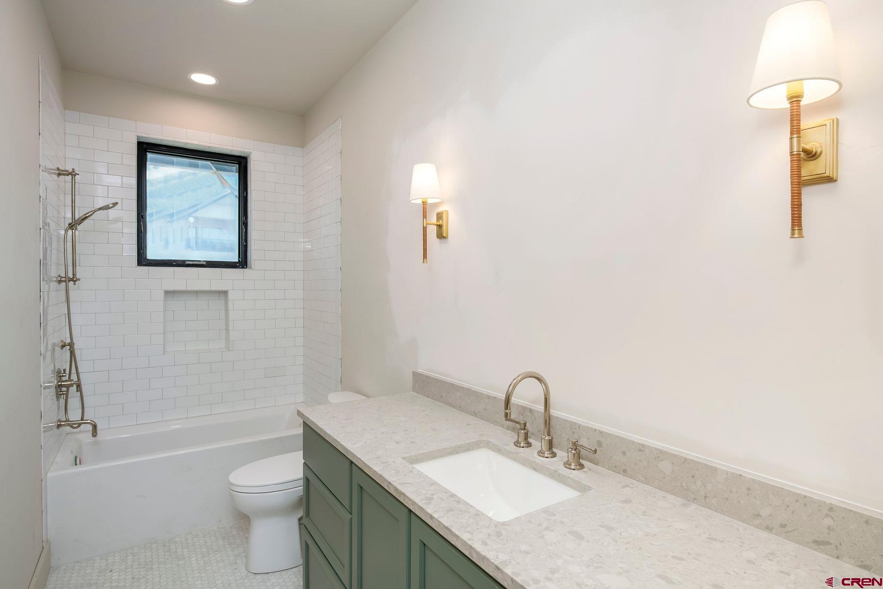 180 Elk Valley Road, Unit 108 Crested Butte, CO 81224 - Photo 16 of 28 a bathroom with a granite countertop sink toilet and shower