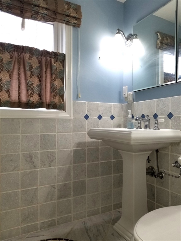 225 Governors Road, Unit 225 Quincy, MA 02169 - Photo 12 of 19 a bathroom with a sink a toilet and mirror