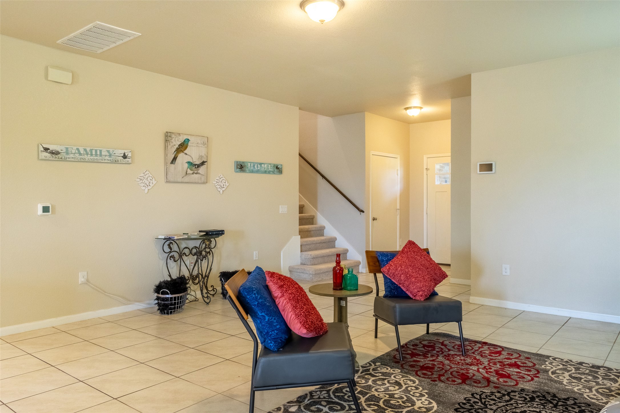 7225 Ranchito Drive Austin, TX 78744 - Photo 6 of 39 Step inside this well-lit living room, featuring a carpeted staircase leading to the upper level.