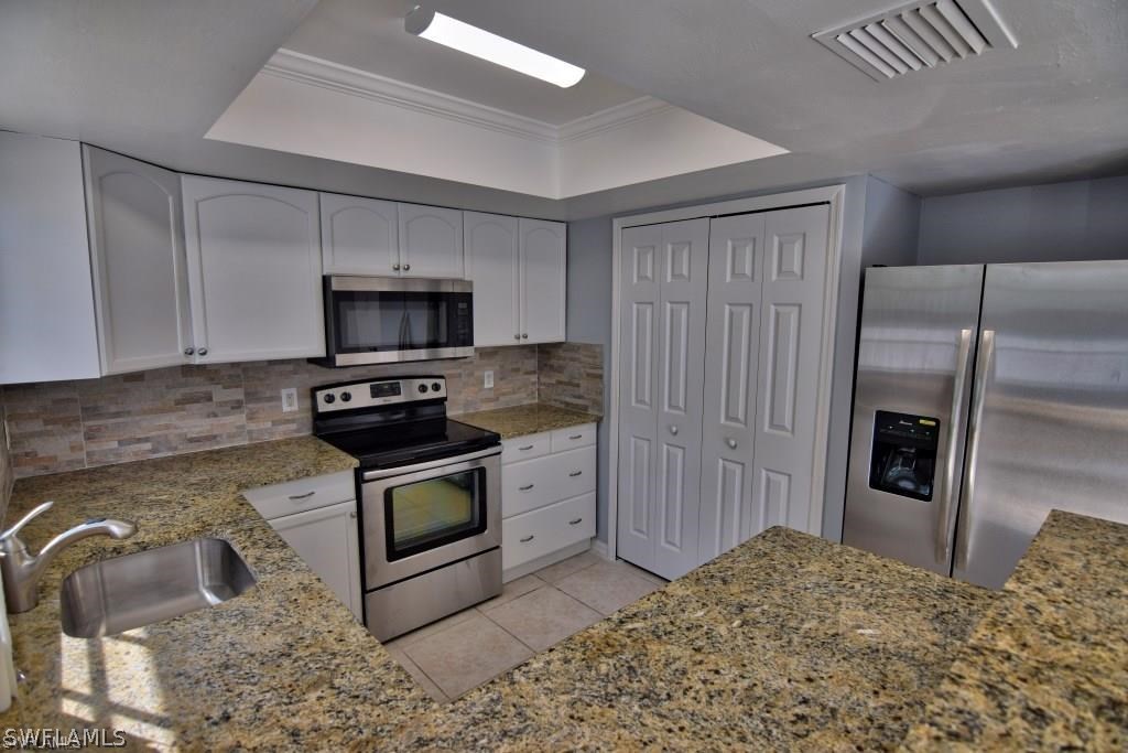 8128 Anhinga Road Fort Myers, FL 33967 - Photo 5 of 12 a kitchen with a sink stove and refrigerator